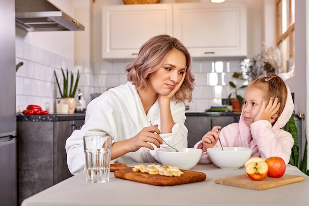 Mère et enfant fille assise ne veulent pas manger le matin