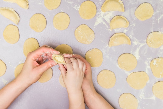 Mère et enfant font des raviolis