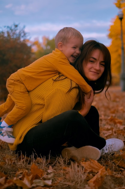Photo mère et enfant garçon jouant dans le parc d'automne famille heureuse mère et bébé à l'extérieur dans le parc