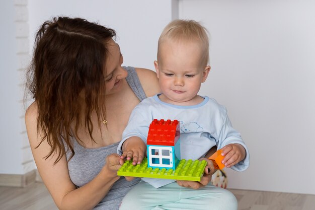 Mère et enfant jouant et découverte à l'intérieur d'une maison