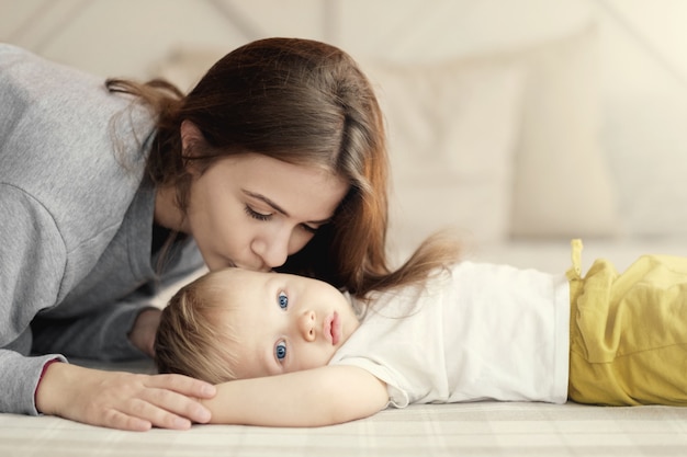 mère et enfant sur le lit, maman embrasse son fils, sentiments, relation mère-enfant,