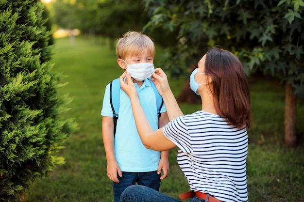 La mère et l'enfant portant un masque vont à l'école lors d'une épidémie de coronavirus ou de grippe.