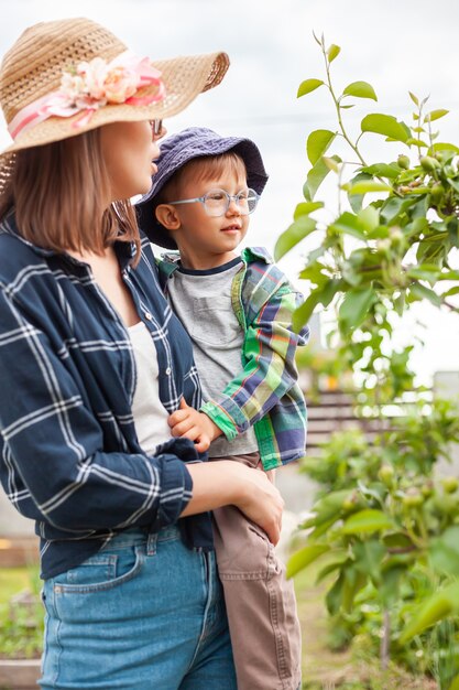 Mère et enfant près de l'arbre, jardinage dans le jardin d'arrière-cour