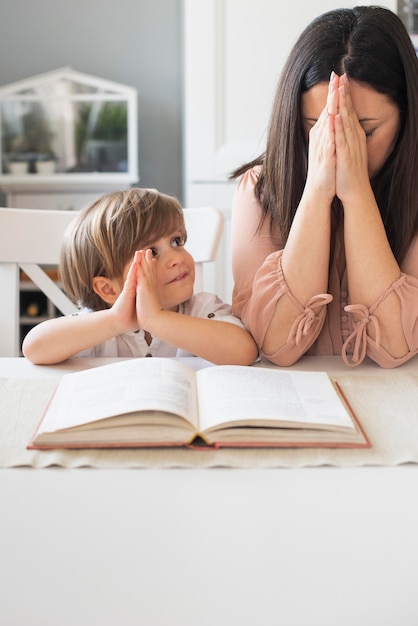 Photo mère et enfant priant ensemble