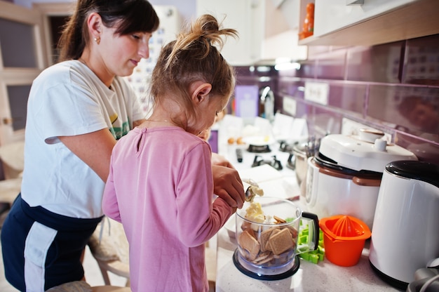 Mère avec enfants cuisinant dans la cuisine, moments heureux pour les enfants.