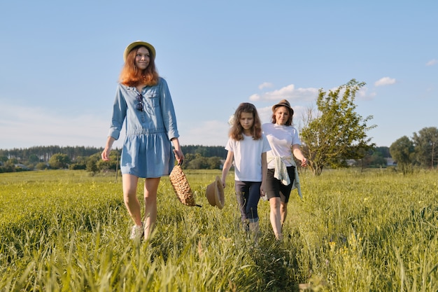 Mère avec enfants deux filles marchant le long de la route de campagne