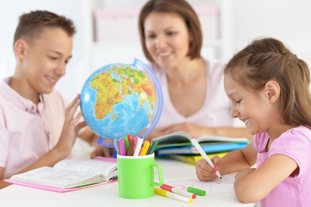 Mère avec enfants faisant leurs devoirs à la maison