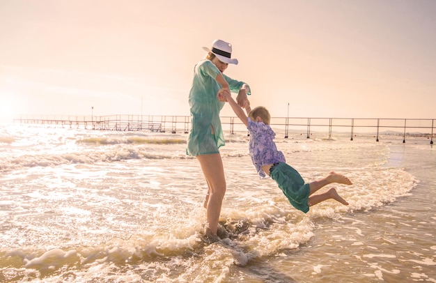 mère et enfants jouent dans la mer sur la plage