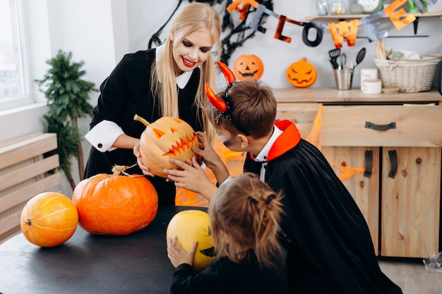 Mère et enfants tenant citrouille et passer un moment amusant à la maison. Halloween