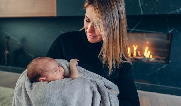 Mère étreignant son bébé devant la cheminée