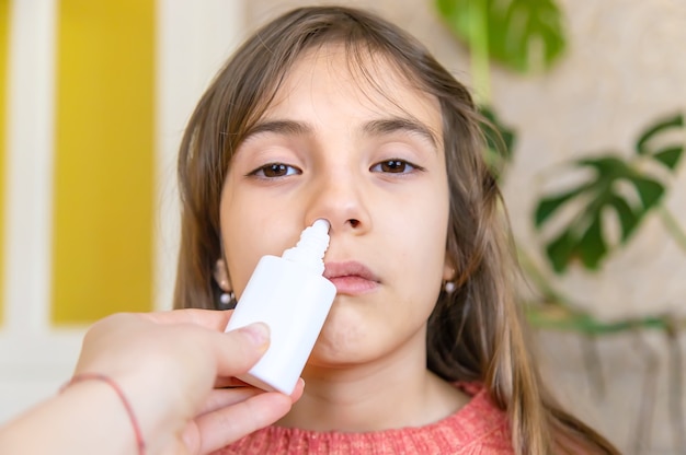 La mère fait couler des médicaments dans le nez de l'enfant. Mise au point sélective. Gens.