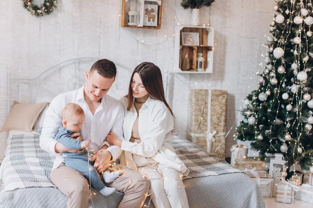 mère de famille heureuse, père et enfant. Sapin de Noël