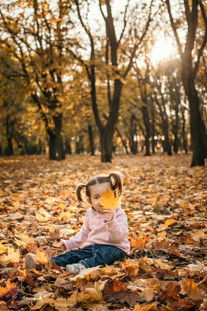 Mère de famille heureuse et petite fille jouant à l'extérieur dans le parc d'automne petite fille et sa mère en