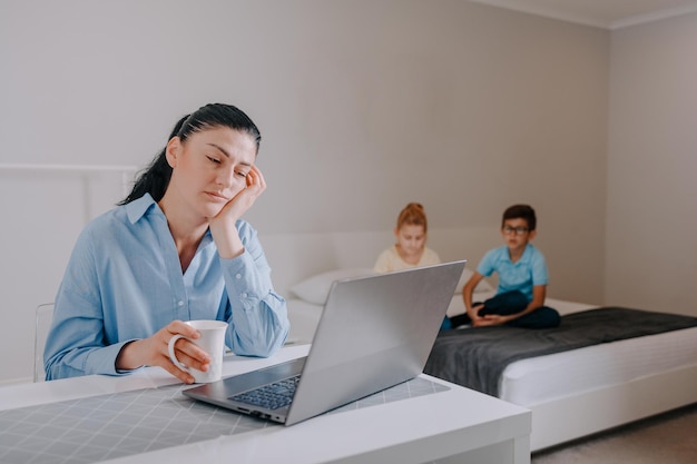 Mère fatiguée de 2 enfants stressée par le travail à domicile