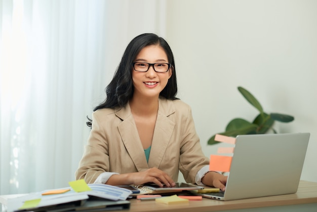 Mère de femme d'affaires asiatique travaillant à la maison avec un ordinateur portable. Concept pour le travail à domicile.