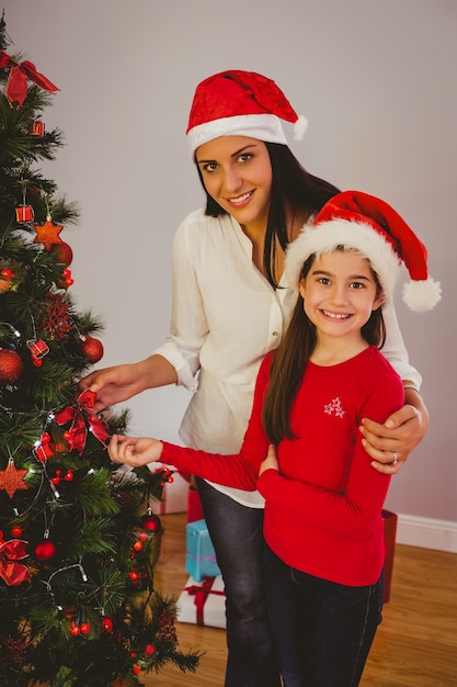 Mère et fille accroché des décorations de Noël sur l&#39;arbre