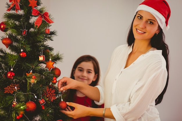 Mère et fille accroché des décorations de Noël sur l&#39;arbre