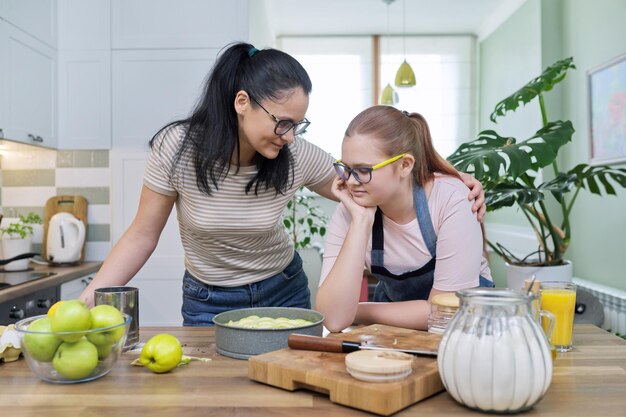 Mère et fille adolescente cuisinant à la maison dans la cuisine