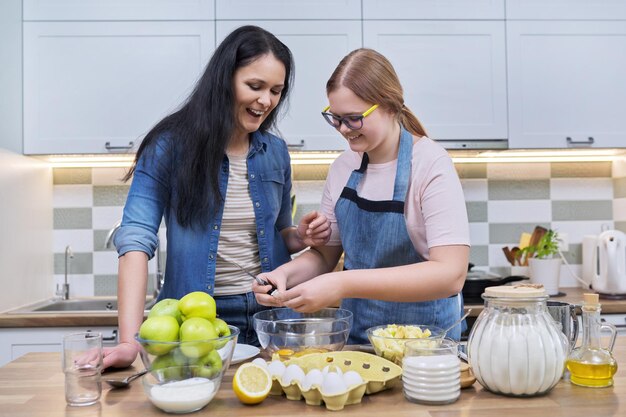 Mère et fille adolescente cuisinant à la maison dans la cuisine