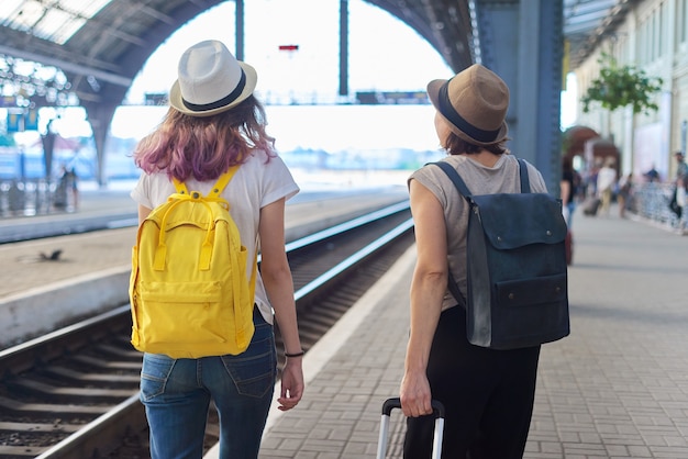 Mère et fille adolescente avec valise de sacs à dos marchant dans la gare