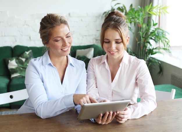 Mère et fille adulte utilisant une tablette à la maison