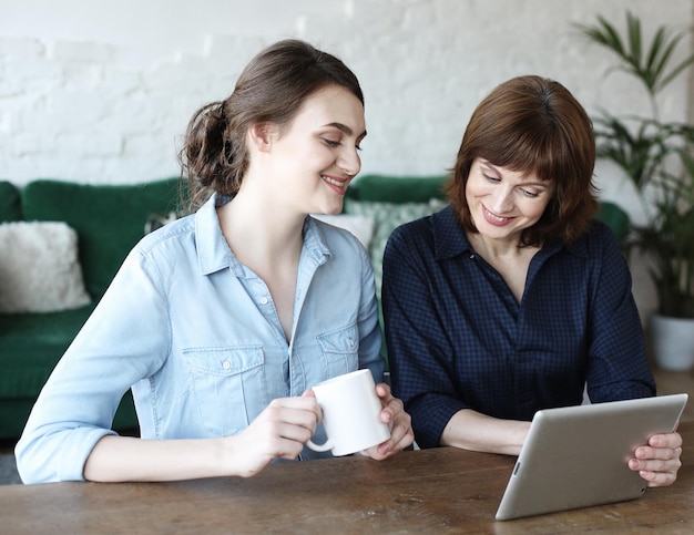 Mère et fille adulte utilisant une tablette à la maison