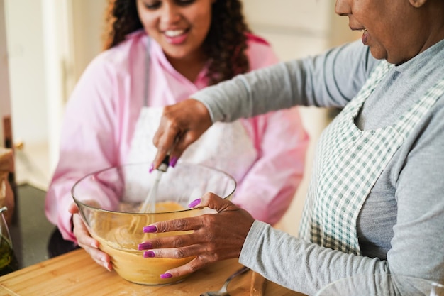 Mère et fille africaines préparant un gâteau au yaourt sans gluten à la maison concept de vie familiale de cuisson se concentrer sur la main de la mère