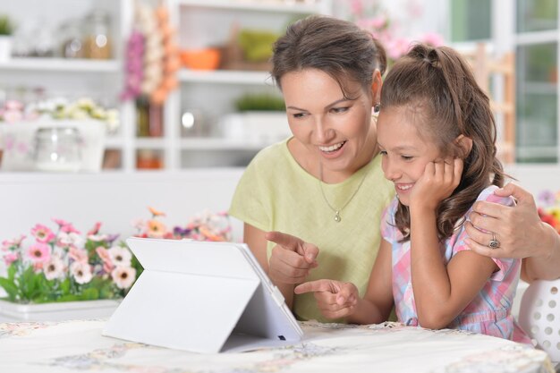 Mère et fille à l'aide d'une tablette moderne