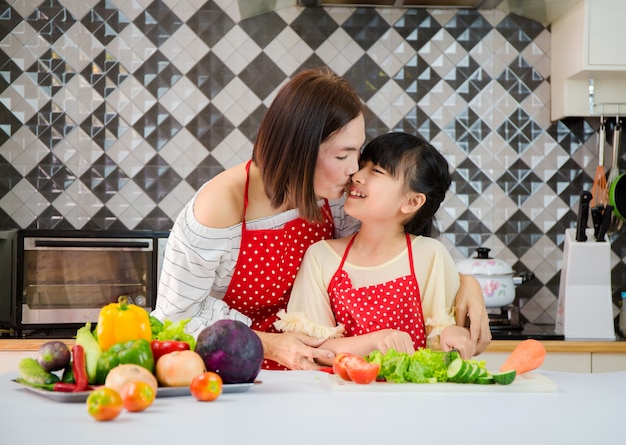 Mère et fille aident à préparer des légumes dans la cuisine.Concept familial heureux