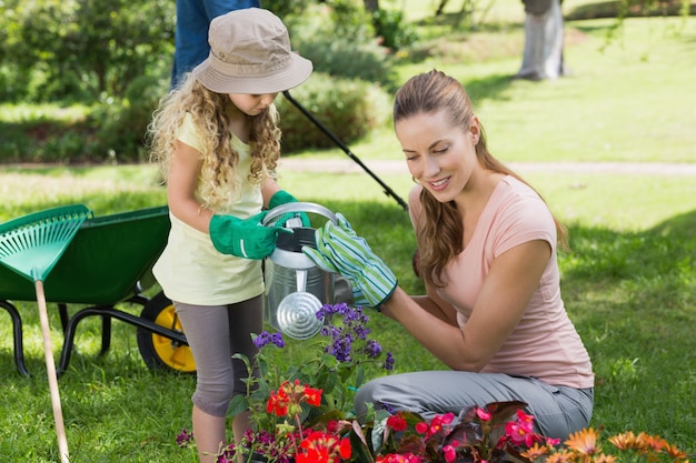 Mère avec fille arroser les plantes