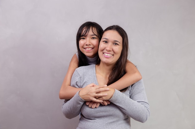 Mère et fille asiatiques sur fond avec un espace pour le texte. Notion de fête des mères