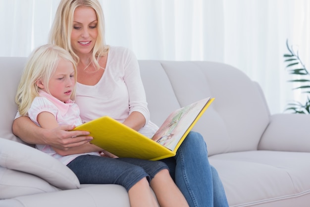 Mère et fille assise sur le canapé