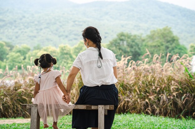 Mère et fille assise sur fond de paysage de montagne