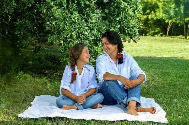 Mère et fille assise sous un chêne dans un parc