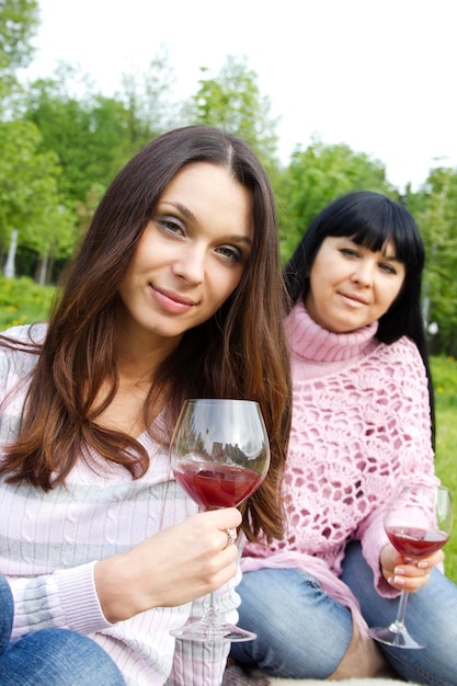 Mère et fille buvant du vin à l'extérieur