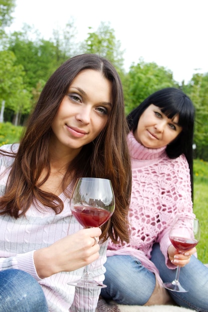 Mère et fille buvant du vin à l'extérieur