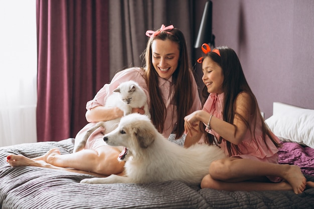 Mère et fille avec chaton et chien