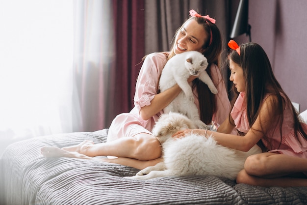 Mère et fille avec chaton et chien