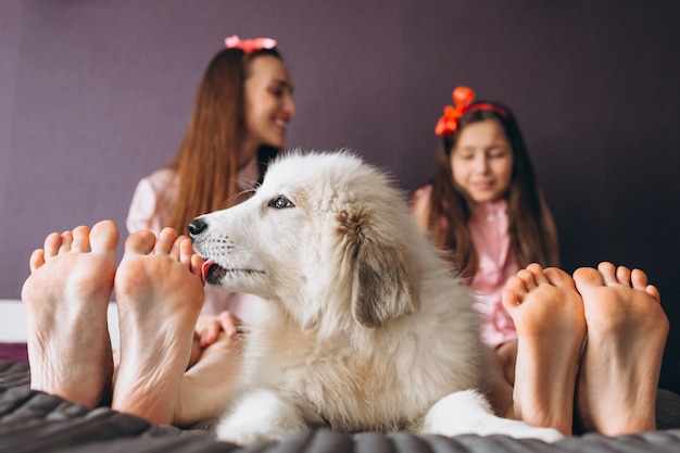 Mère et fille avec un chien au lit