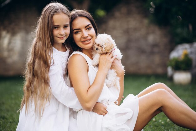 Mère avec fille avec chien maltipa dans la cour arrière