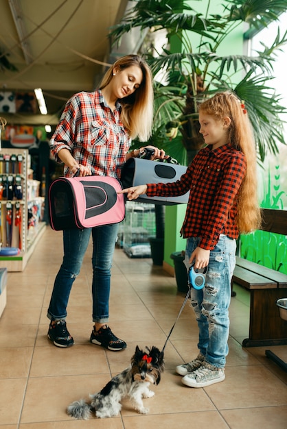 Mère avec fille en choisissant le sac en animalerie