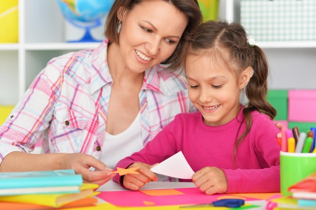 Mère et fille collent et coupent du papier