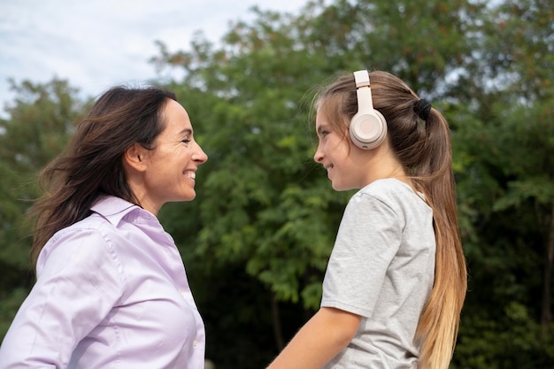 Mère et fille de coup moyen avec des écouteurs