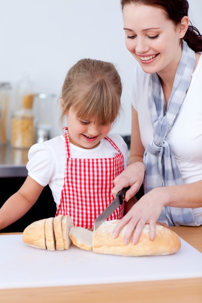 Mère et fille coupant du pain