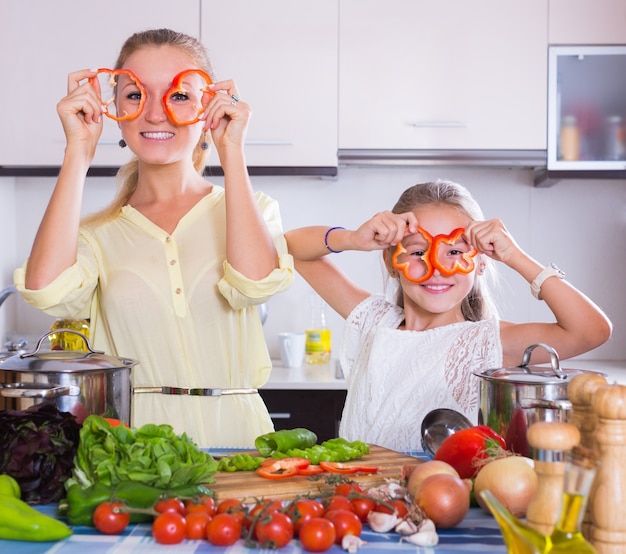 Mère avec fille cuisine légumes