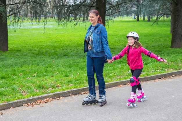Mère et fille dans le parc avec des patins à roulettes