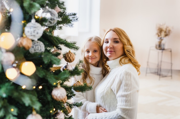 Mère et fille debout près de l'arbre de Noël