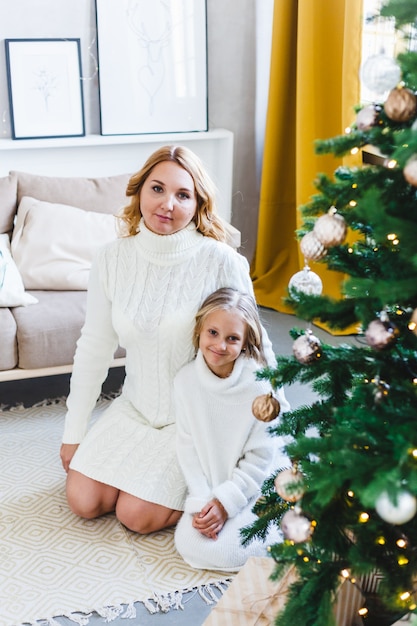 Mère et fille debout près de l'arbre de Noël