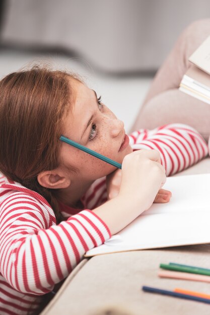 Mère et fille dessinant avec des crayons colorés sur le livre