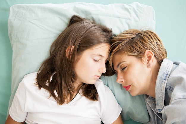 Mère et fille dormant ensemble dans un lit d'hôpital